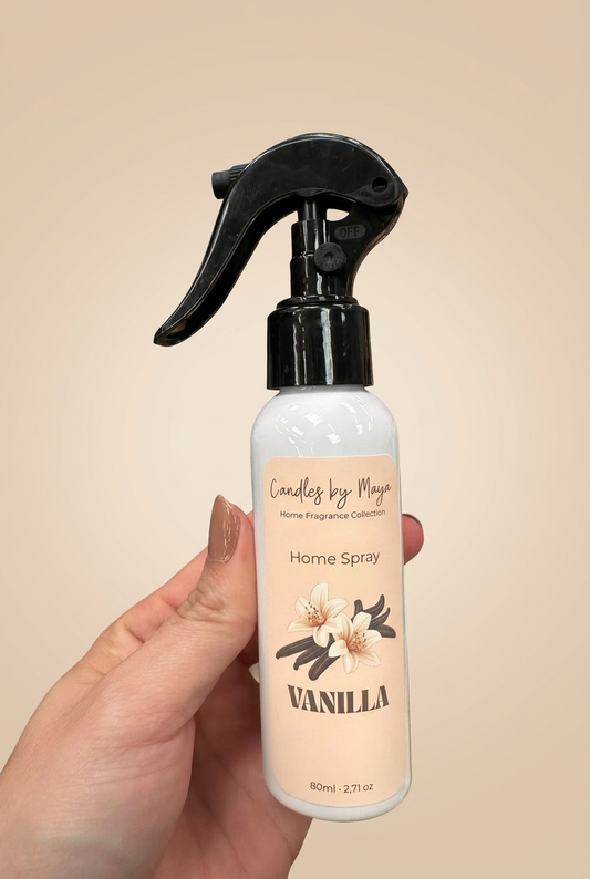 Vanilla Home Spray held in a hand against a light beige studio background